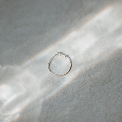 Bague anneau fin lisse Tiggy en argent massif isolée sous un rayon de soleil poétique.
