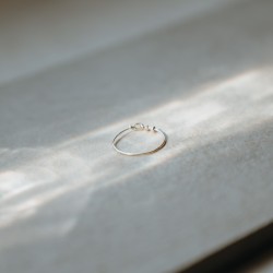 Focus sur le fermoir délicat et torsadé fait main de la bague fine lisse Tiggy en argent.
