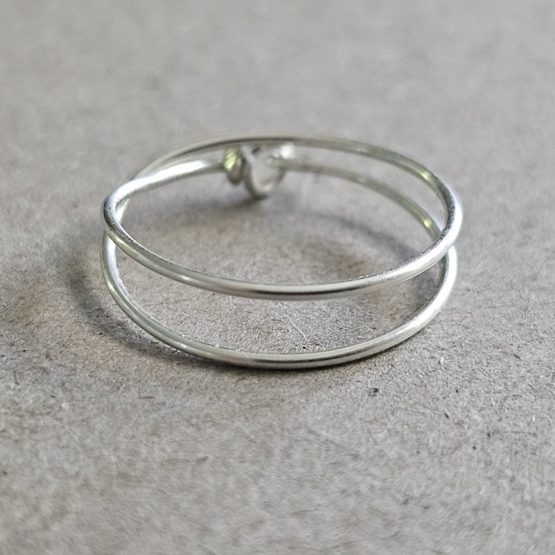 Bague double tour Cece en argent 925 massif posée à plat, dévoilant son fermoir double boucle artisanal.