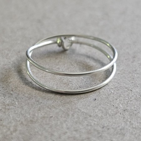 Bague double tour Cece en argent 925 massif posée à plat, dévoilant son fermoir double boucle artisanal.