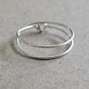 Bague double tour Cece en argent 925 massif posée à plat, dévoilant son fermoir double boucle artisanal.