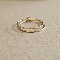 Bague double tour Cece en or Gold Filled posée à plat, dévoilant son fermoir double boucle artisanal.