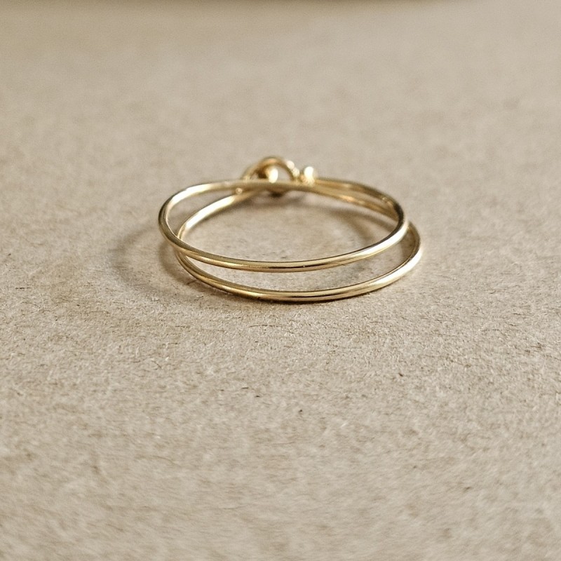 Bague double tour Cece en or Gold Filled posée à plat, dévoilant son fermoir double boucle artisanal.