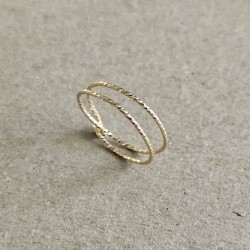 Gros plan sur les reflets facettés et le fermoir à boucles de la bague double rang Claudia en or laminé.