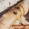Jonc Una en gold filled 14K avec labradorite et grenat sertis porté en accumulation sur la plage