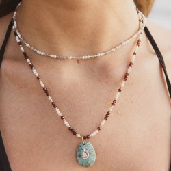 Portrait buste d'une femme portant le collier de la collab Noblesse Sauvage mariant l'éclat des perles et de la labradorite.