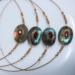 Joncs Una jonc lisse fin or laminé et labradorites aux reflets bleutés, verts et orangés serti d'un grenat