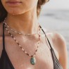Gros plan sur la peau mouillée d'une femme portant le collier en perles de culture et labradorites aux reflets bleutés.