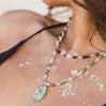 Détail macro du collier artisanal alternant perles de culture blanches, pierres facettées de grenat bordeaux et turquoises