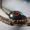 Focus sur les ornements du set dulce et sa labradorite incrustée d'un grenat ceinturée d'une chaine dorée