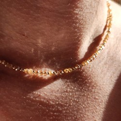 Gros plan Collier Blossom Halo Champagne en Gold Filled 14k et perles de verre beiges porté au cou