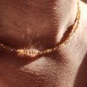 Gros plan Collier Blossom Halo Champagne en Gold Filled 14k et perles de verre beiges porté au cou
